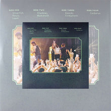 Cargar imagen en el visor de la galería, Back cover of King Buffalo's "Live at Freak Valley Vol. 2" double vinyl. The grey cover features the tracklist for four sides in the upper portion. Below the text is a framed live photograph of the band performing on stage in front of a crowd with their hands raised.
