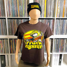 Charger l'image dans la galerie, A mannequin wearing a dark brown graphic t-shirt and a black beanie with yellow 'Truck Fighter' text, set against a background of vinyl record shelves.