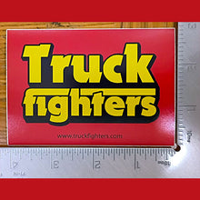 Cargar imagen en el visor de la galería, Sticker with 'Truckfighters' text on a red background, next to a ruler for size reference.